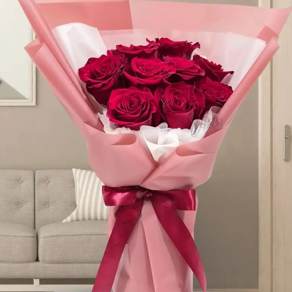 Sweet Scarlet Symphony a bouquet of vibrant red roses wrapped in pink paper with a decorative bow– Petal Frost flower shop