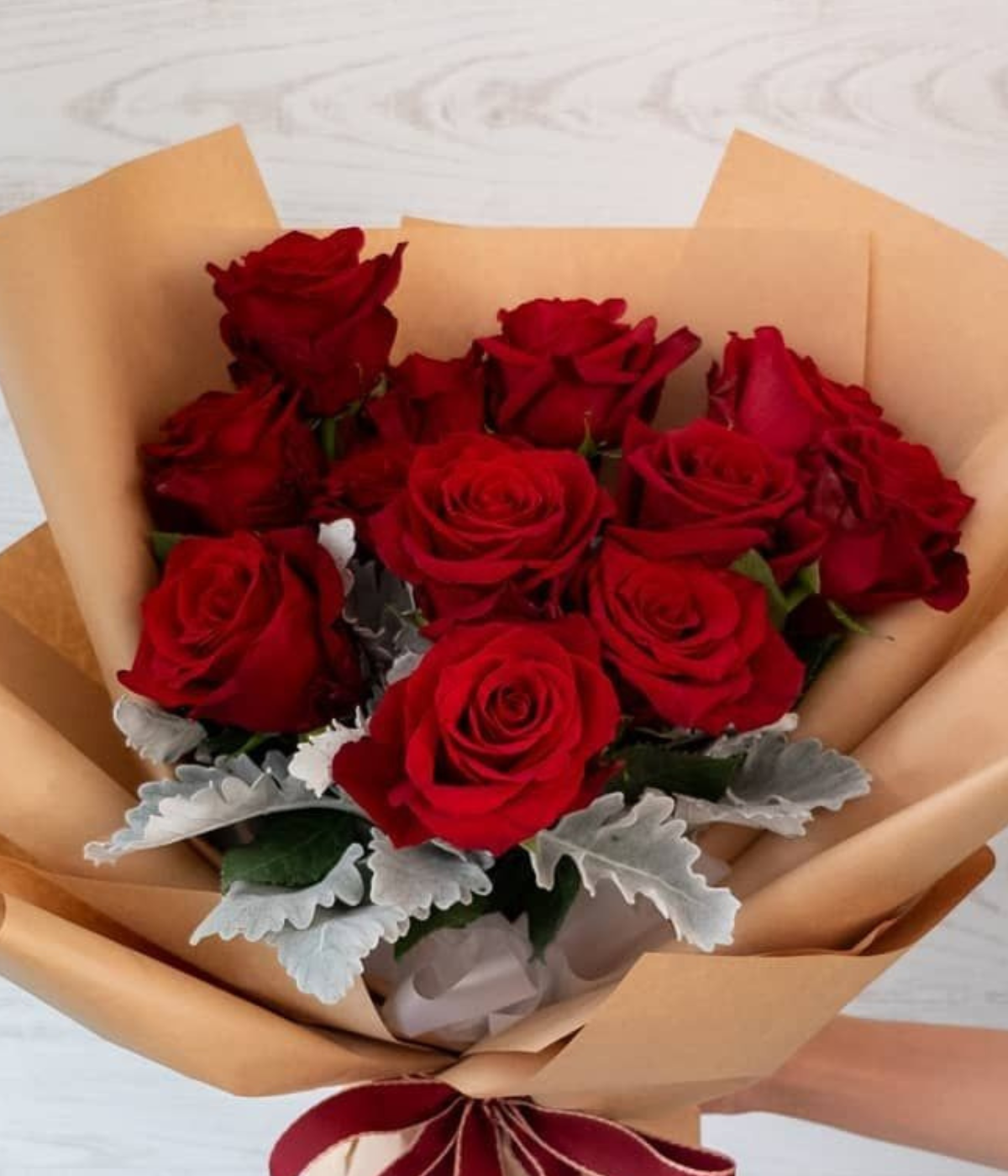 Valentine’s Bliss Bouquet of red roses with green leaves, wrapped in brown paper with a red ribbon - Petal Frost Dubai